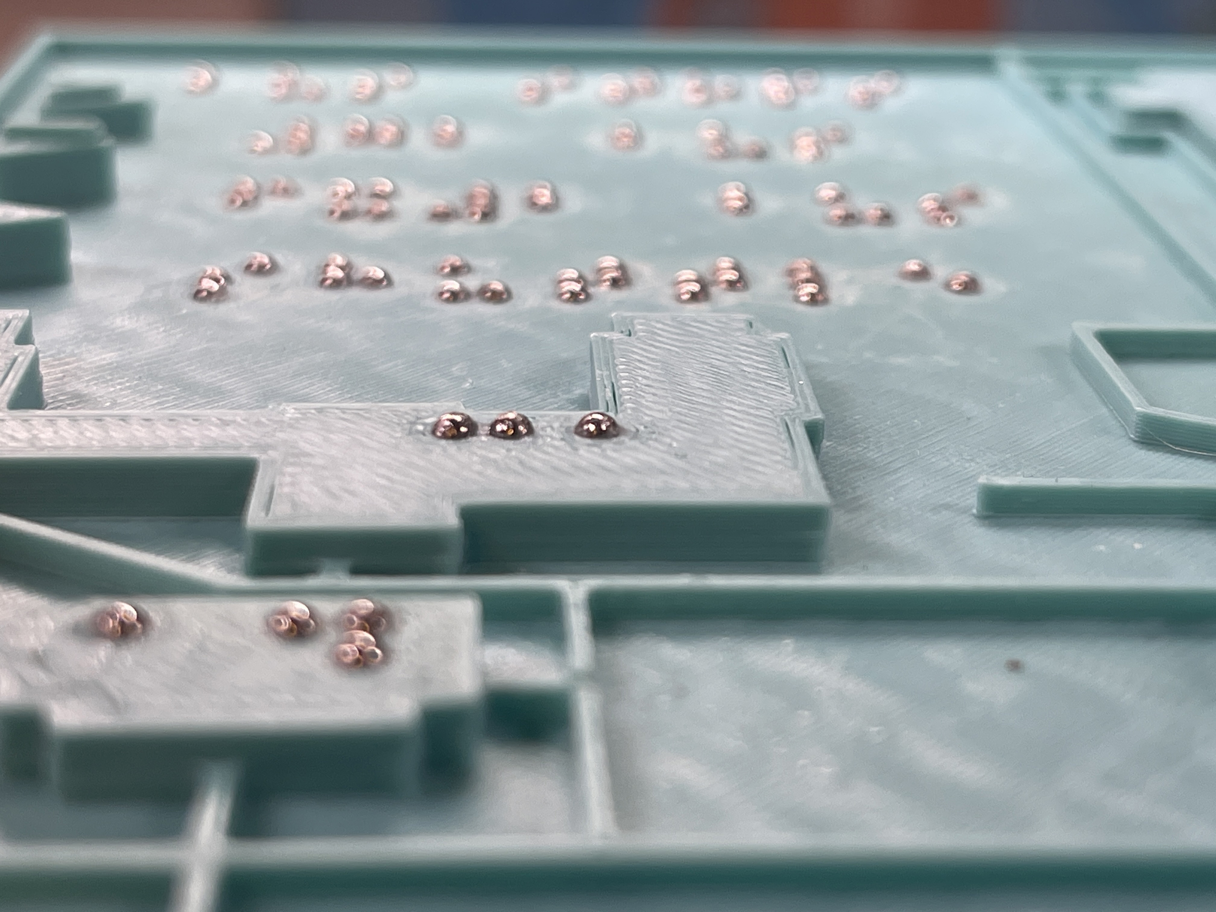 A 3D-printed campus map with embeded metal bbs making raised braille dots generated by the Braille Maker tool